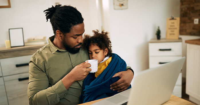 Father giving his sick daughter tea